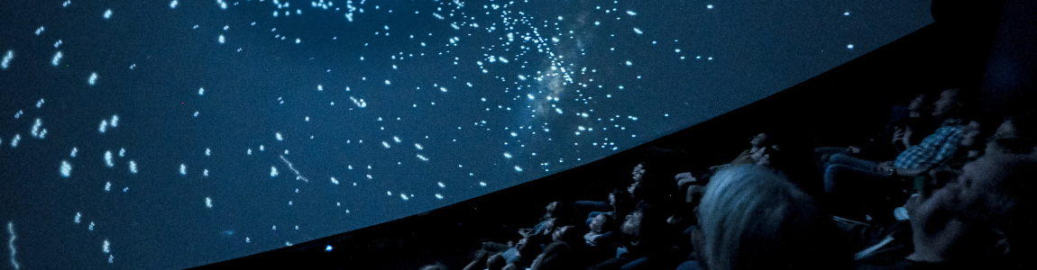 Bilde av salen i Planetariet. På skjermen vises stjernehimmelen.